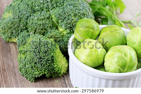 Brussels sprouts and  broccoli , fresh vegetables on wooden background