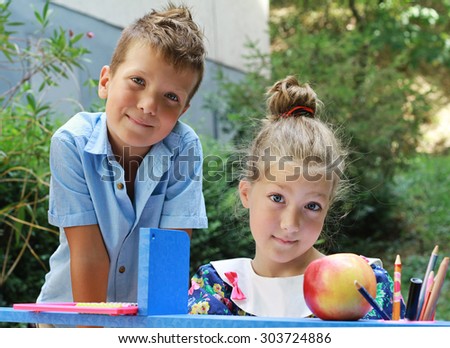 Stylish boy and girl playing school outside. Education and kids fashion concept