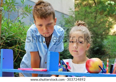Stylish boy and girl playing school outside. Education and kids fashion concept