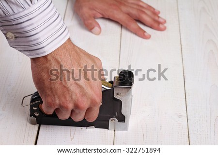 Close up on male hand using electric nail hammer machine. Man Doing DIY at home