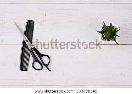 Scissors and comb on white rustic wooden background. Hairdresser salon concept. Haircut  accessories