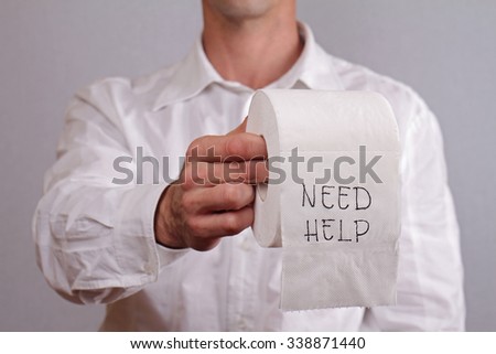 Man holding toilet paper with words need help written on it