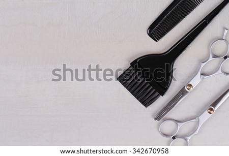 Scissors,comb and brush for hair coloring on white wooden background. Hairdresser salon concept. Haircut accessories