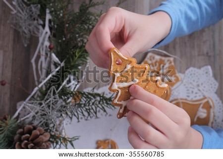 New year and family concept. Kid making christmas tree decoration from gingerbread cookie close up. Baking with children