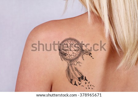 Laser tattoo removal concept. Beautiful young woman with tattoo on her back