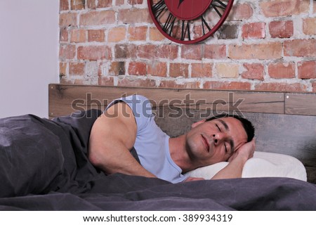 Sleeping man: Young handsome man sleeping comfortably  in bed