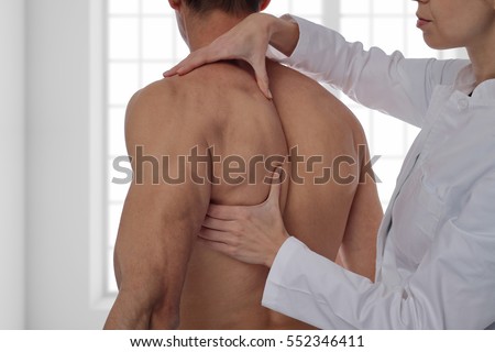 Chiropractic, osteopathy, manual therapy, acupressure. Therapist doing healing treatment on man's back. Alternative medicine, pain relief concept