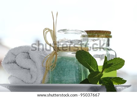 Spa collection with white towel, bath salt, massage oil, mint, isolated on white.