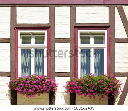 Old timber frame-work house with windows and flower-boxes - Some old timber frame-work house with windows and flower-boxes using the example of a townhouse in Wernigerode, Germany, Europe.