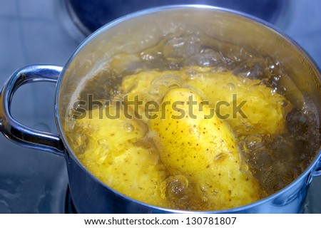 Cooking Potatoes In Boiling Water - Potatoes are being cooked in boiling water in a cooking pot.