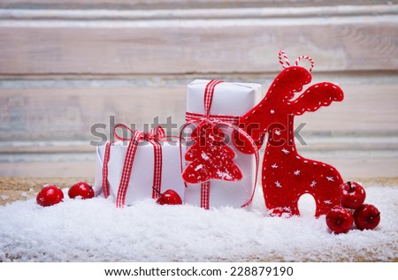 christmas presents lying in sno? decorated with red apples and deer