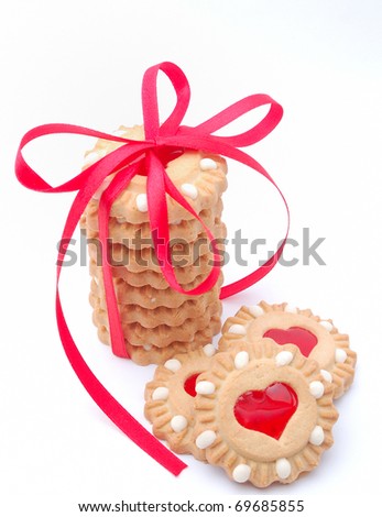 valentine cookies with red heart fasciated with a red ribbon with a bow on white background