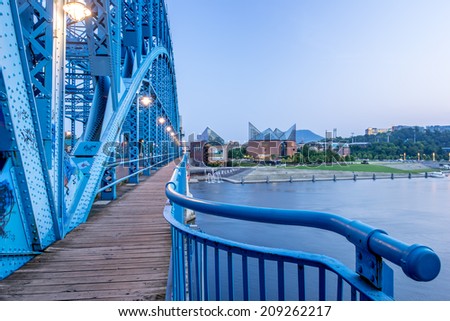 John Ross Bridge on Market Street in Chattanooga Tennessee, looking out over the Tennessee River toward downtown and the Tennessee Aquarium at dusk.
