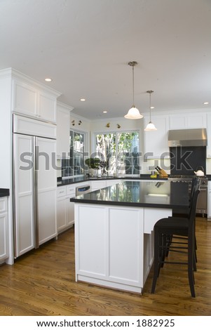 Shot of a remodeled kitchen featuring white custom cabinets and stainless steel appliances.