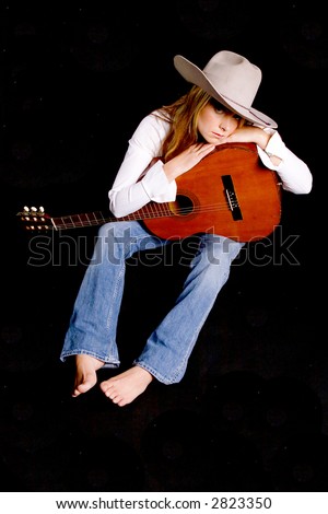 Shot of a sexy girl with a guitar and a cowboy hat