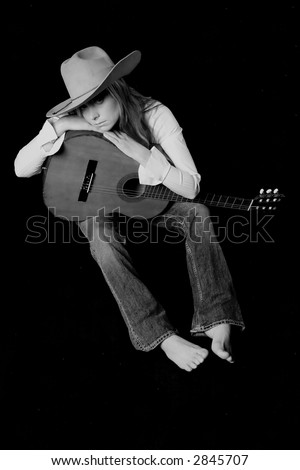 Shot of a sexy girl with a guitar and a cowboy hat
