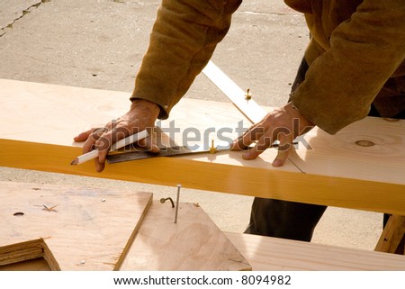 Shot of a carpenter carefully laying out a stair stringer to be cut.