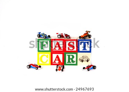 Children\'s blocks spelling FAST CAR with toy cars.