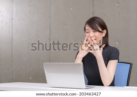 Young Asian woman  surprised to watch a laptop computer.