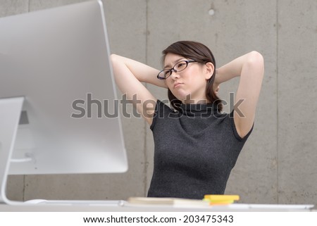 Young Asian woman thinking to watch a desktop computer.