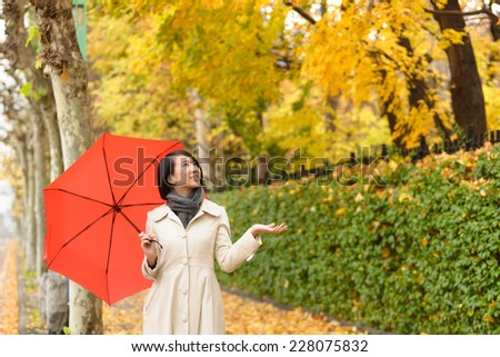 Young Asian woman holing up red umbrella.