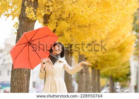 Young Asian woman put up red umbrella.