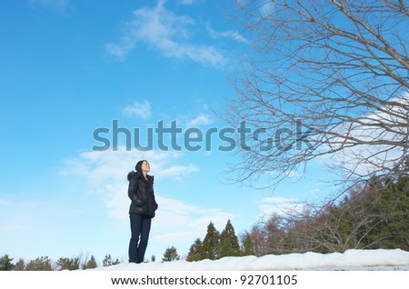 Asian woman in winter fashion, with withered tree