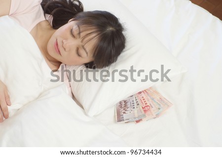 Sleeping young woman with New Taiwan Dollars