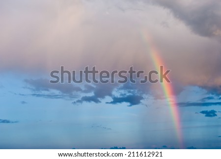 Bright rainbow in the sky with clouds on sunset