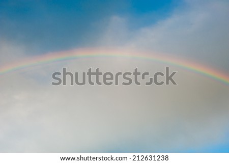 Bright rainbow in the sky with clouds on sunset