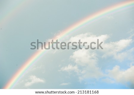 Bright double rainbow in the sky with clouds
