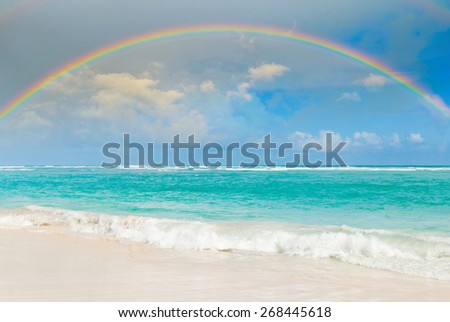 Bright rainbow in the sky with clouds above the sea