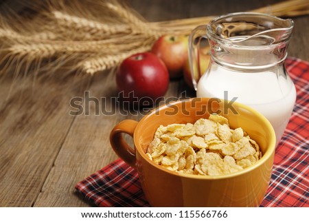 Bowl of cereals and the glass of milk on the wooden table