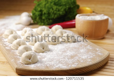 Meat dumplings on the kitchen board on the bamboo table