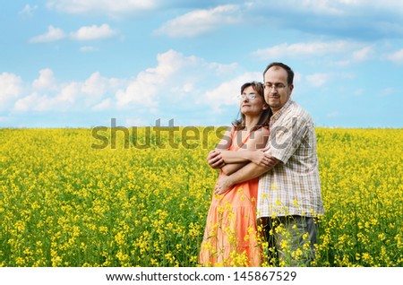 Happy man and woman in yellow meadow at summer