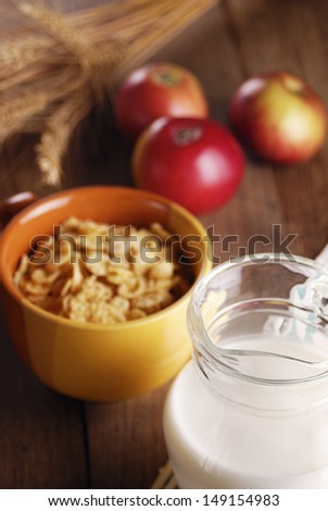 Bowl of cereals and a glass of milk on the wooden table
