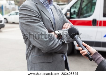 Reporter holding a microphone, making a live broadcast.