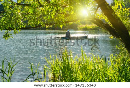 Inveterate fisherman in a boat on the lake. Summer fishing