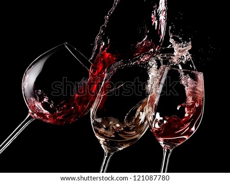 Red, white and rose wine splash on black background