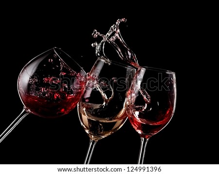 Red, white and rose wine splash on black background