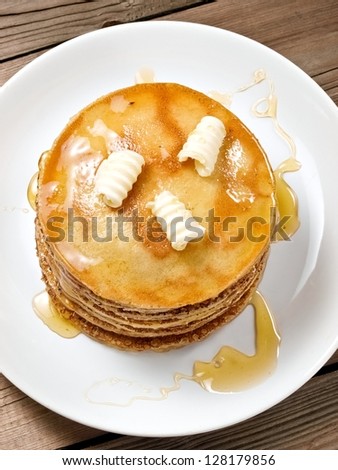 Small pancakes with honey and butter, top view, close up