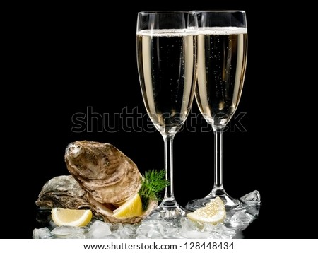 Two champagne glasses with oysters and lemon slices