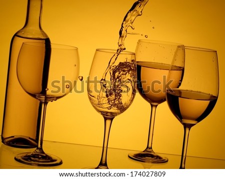Wine pouring on yellow background