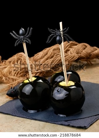 Three black poison toffee Halloween apples