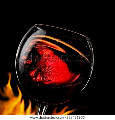 Red wine glass swirl with fire, close up