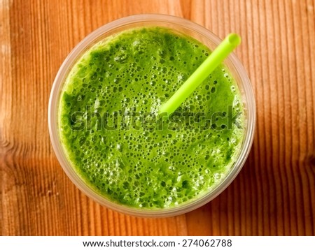 Green smoothie on wood, top view