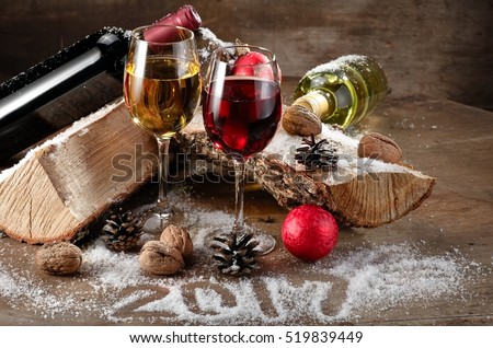 Red and white wine glasses and bottles on wood, 2017 Year