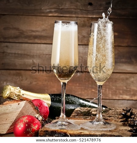 Two champagne glasses on firewood pouring