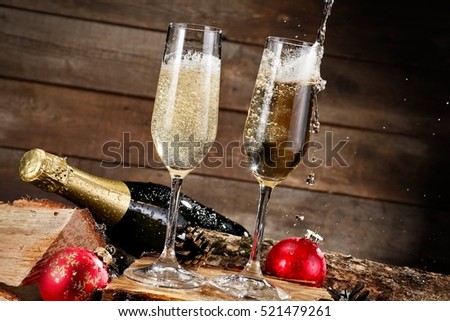 Two champagne glasses pouring on wooden background