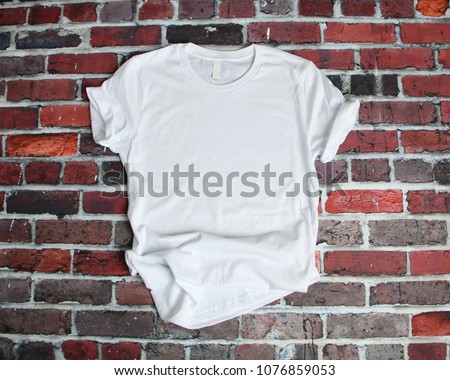 Flat lay mockup of white tee shirt on brick background